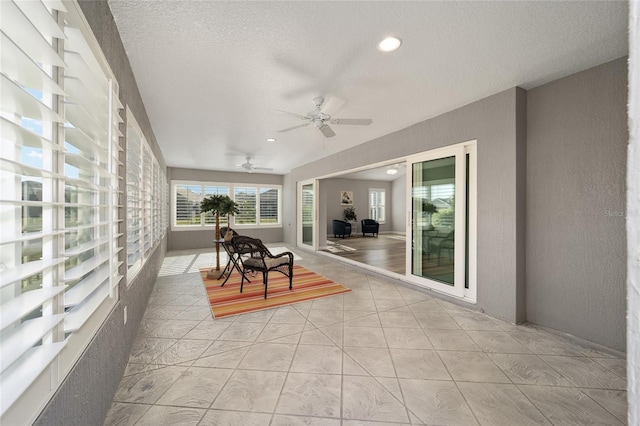 sunroom / solarium featuring ceiling fan