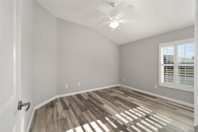 empty room with lofted ceiling, hardwood / wood-style floors, and ceiling fan