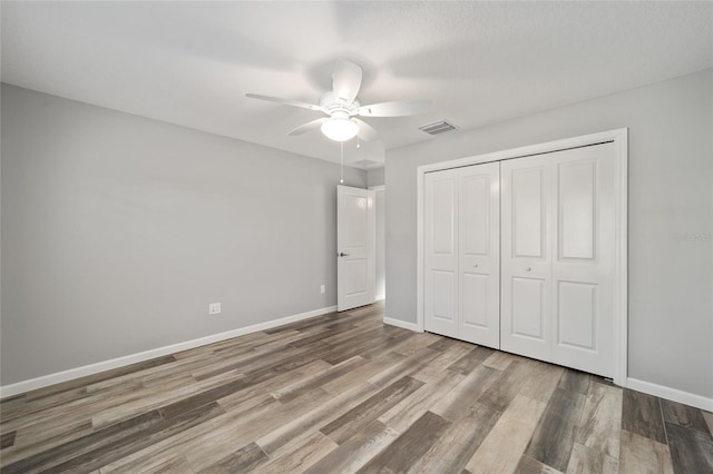 unfurnished bedroom with a closet, ceiling fan, and hardwood / wood-style floors