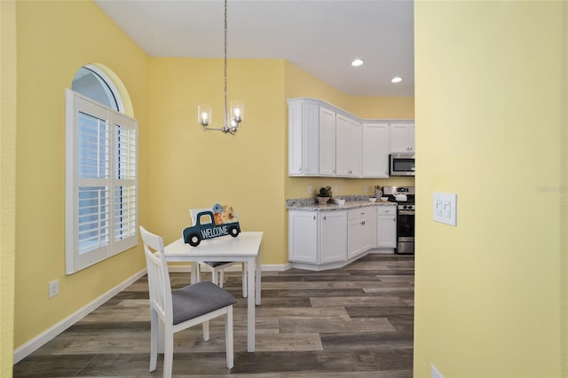 kitchen featuring white cabinetry, stainless steel appliances, dark wood-type flooring, and decorative light fixtures