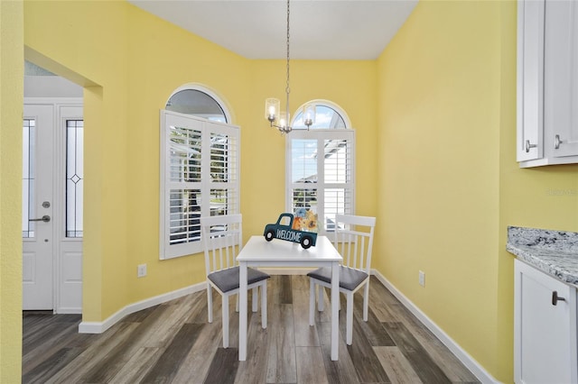 dining space with a chandelier and dark hardwood / wood-style flooring