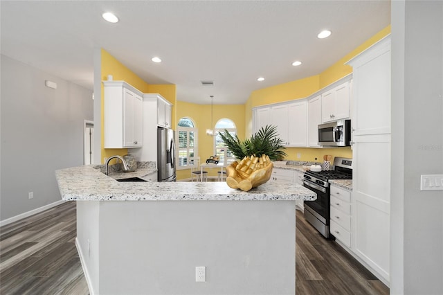 kitchen with dark hardwood / wood-style flooring, appliances with stainless steel finishes, sink, and white cabinets