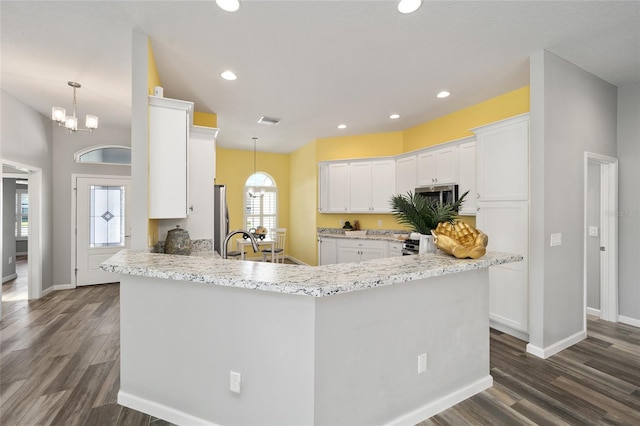 kitchen with pendant lighting, white cabinetry, and dark hardwood / wood-style floors