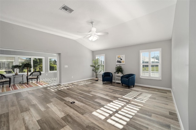 living area featuring light hardwood / wood-style floors, ceiling fan, plenty of natural light, and vaulted ceiling