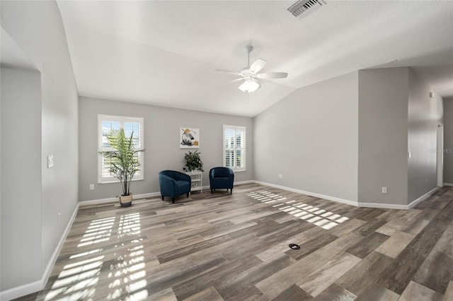 unfurnished room featuring a wealth of natural light, lofted ceiling, hardwood / wood-style flooring, and ceiling fan