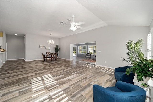 living room featuring hardwood / wood-style floors, vaulted ceiling, and ceiling fan with notable chandelier