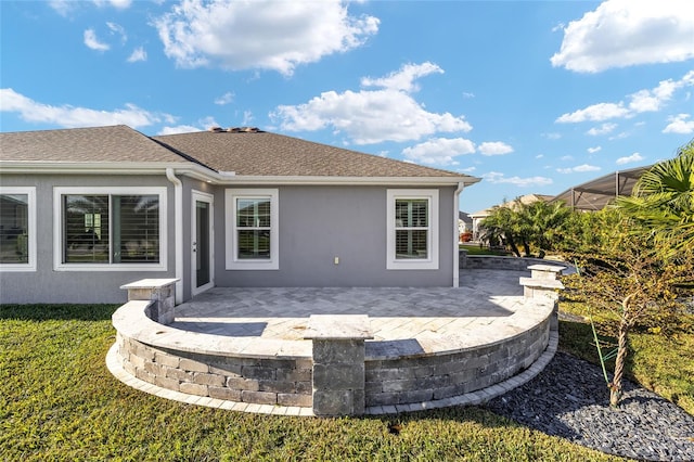 rear view of house with a patio and a yard