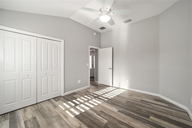 unfurnished bedroom with vaulted ceiling, hardwood / wood-style floors, ceiling fan, and a closet