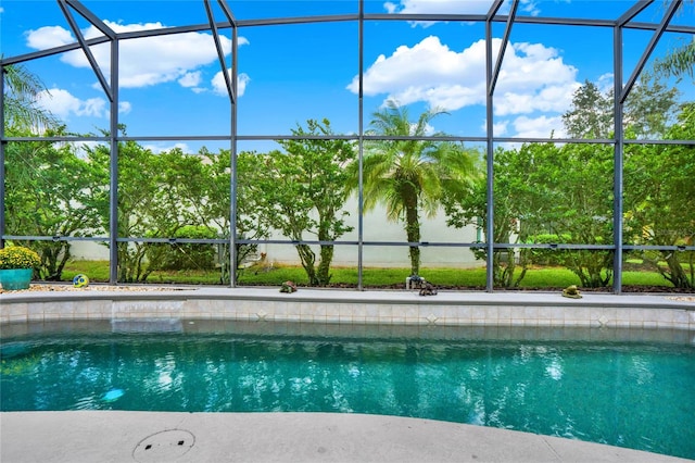 view of swimming pool featuring glass enclosure