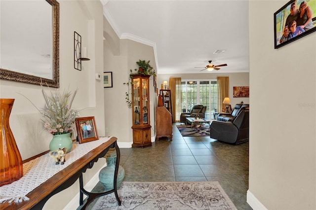 hall featuring dark tile patterned floors and crown molding