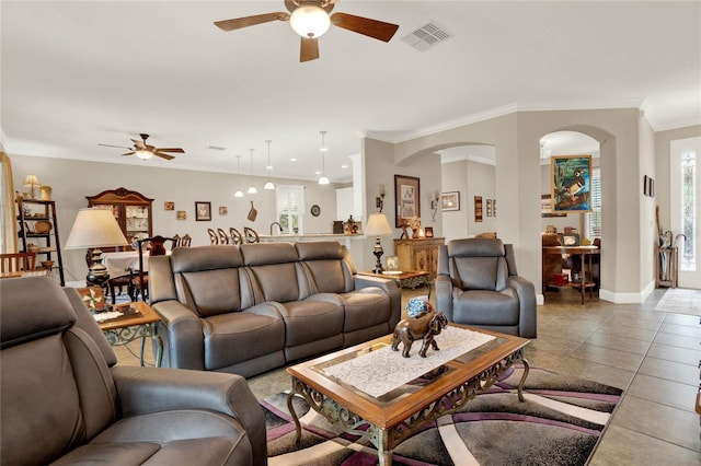 tiled living room featuring ornamental molding and ceiling fan