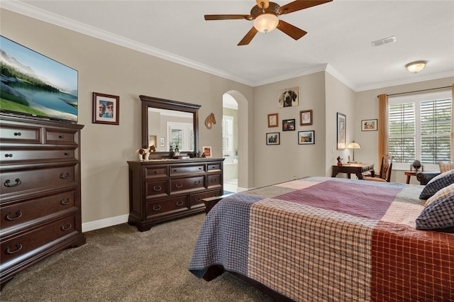 bedroom featuring light carpet, ensuite bath, ceiling fan, and crown molding