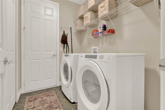 washroom featuring separate washer and dryer and dark tile patterned floors