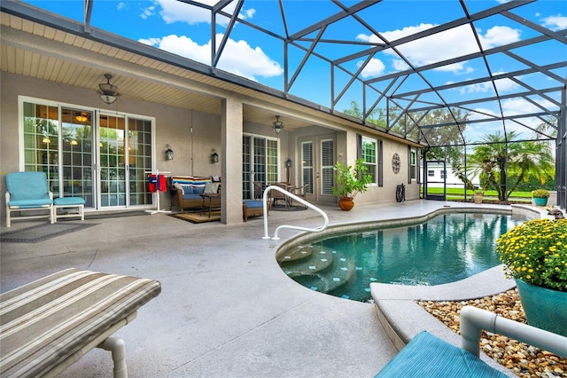 view of swimming pool featuring ceiling fan, glass enclosure, and a patio area