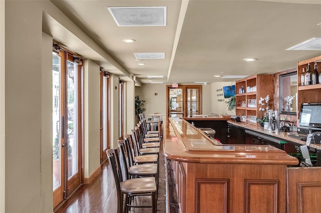 bar with wood-type flooring and french doors