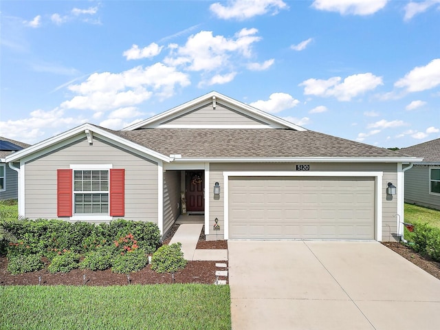 ranch-style house with concrete driveway, roof with shingles, and a garage