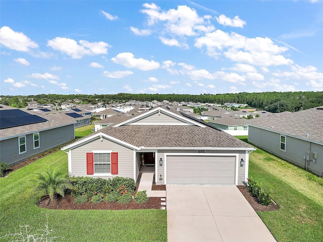 view of front of property with a front lawn, driveway, roof with shingles, and a garage