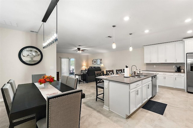 kitchen with sink, an island with sink, white cabinets, appliances with stainless steel finishes, and decorative light fixtures