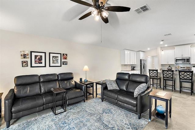 living room featuring light tile patterned floors and ceiling fan