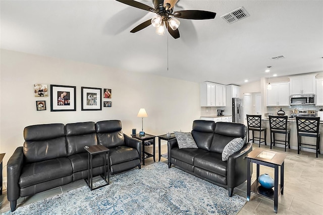 living room featuring a ceiling fan and visible vents