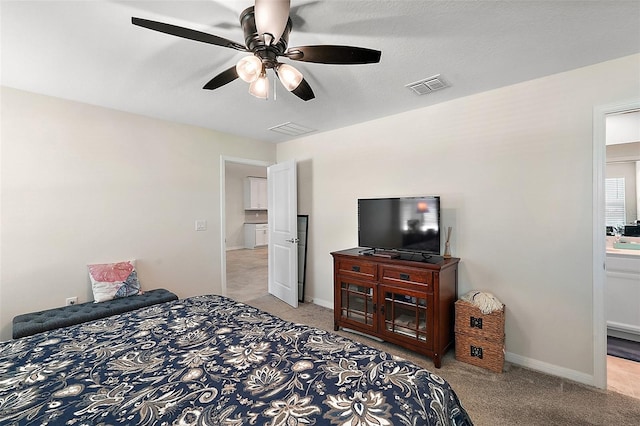 bedroom featuring ceiling fan, light colored carpet, and a textured ceiling