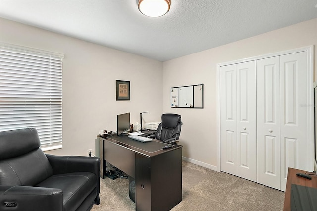 carpeted office space featuring a textured ceiling