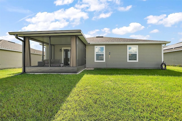 back of property with a yard and a sunroom