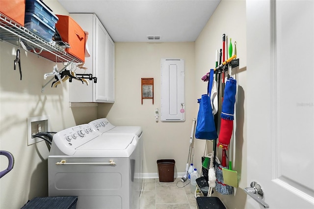 laundry room featuring cabinets, washing machine and clothes dryer, light tile patterned floors, and electric panel