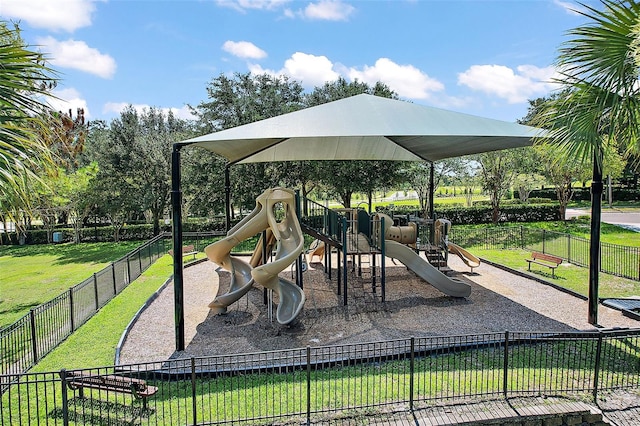 community jungle gym with a lawn and fence
