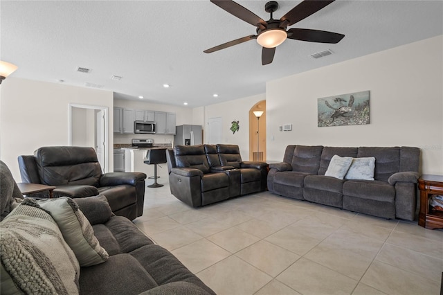 tiled living room with a textured ceiling and ceiling fan