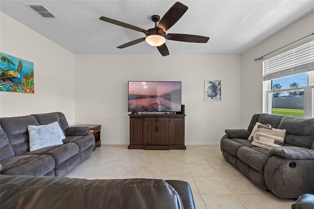 tiled living room with a textured ceiling and ceiling fan