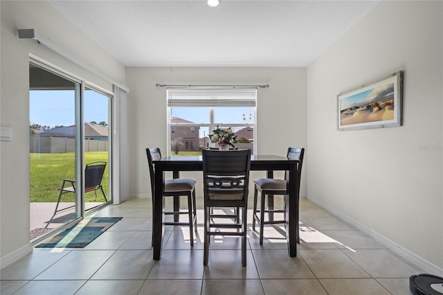 tiled dining area featuring a textured ceiling and a wealth of natural light