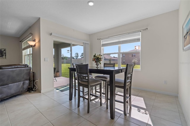 dining area featuring a textured ceiling and light tile patterned floors