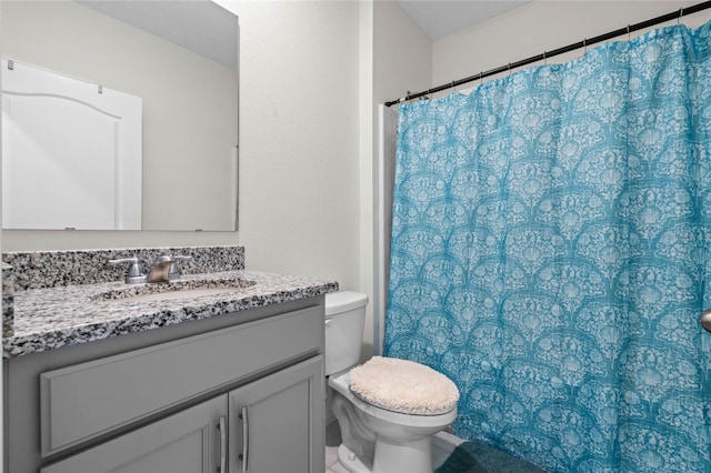 bathroom with walk in shower, vanity, and toilet