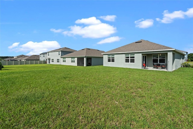 rear view of property with a lawn and a patio