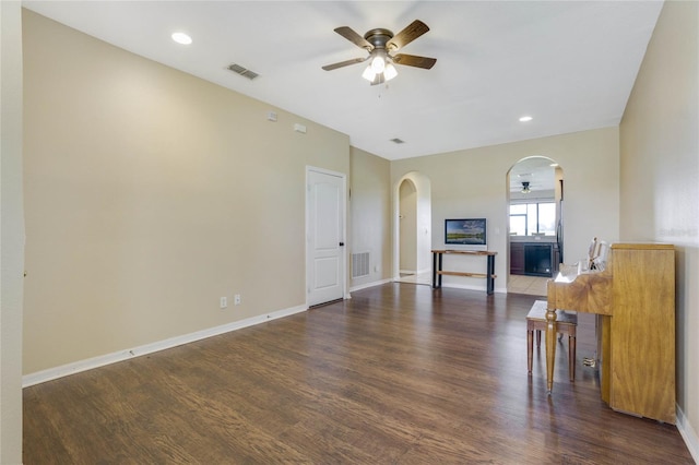 unfurnished living room featuring ceiling fan and dark wood-type flooring