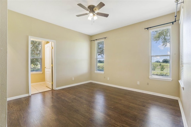 spare room with dark hardwood / wood-style floors and ceiling fan