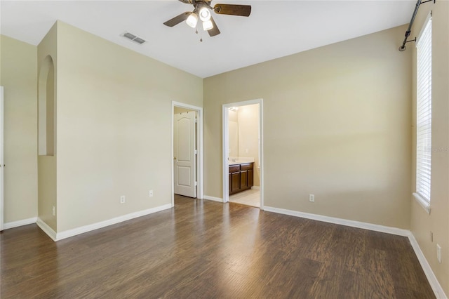 unfurnished bedroom with ensuite bathroom, ceiling fan, and wood-type flooring