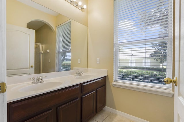 bathroom with tile patterned floors, vanity, and walk in shower