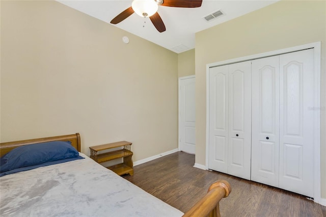 bedroom featuring dark hardwood / wood-style flooring, ceiling fan, and a closet