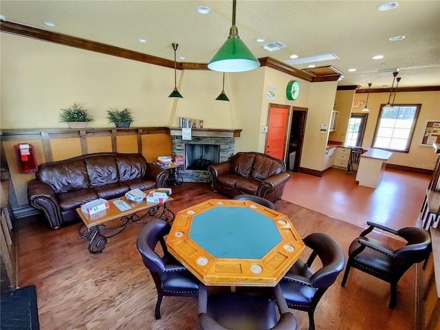 living room featuring hardwood / wood-style flooring, a fireplace, and ornamental molding