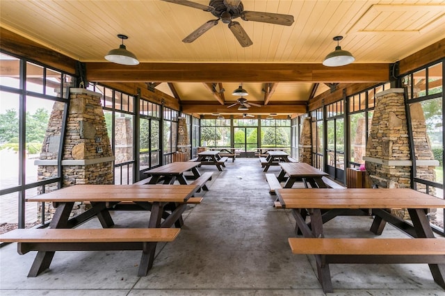 sunroom with vaulted ceiling with beams, ceiling fan, wood ceiling, and a wealth of natural light