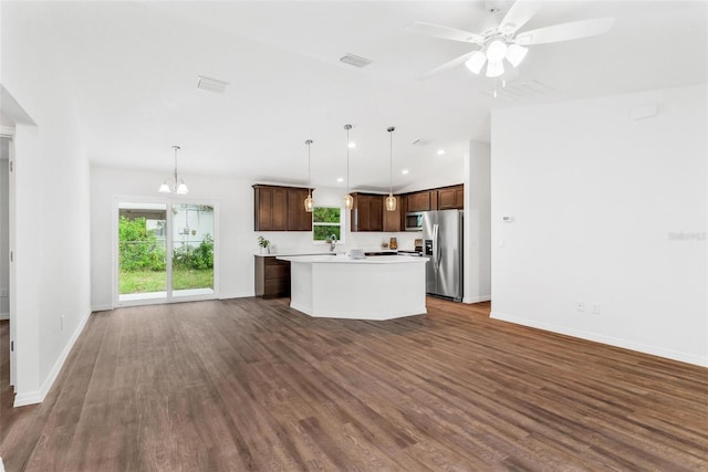 kitchen featuring appliances with stainless steel finishes, a center island, hanging light fixtures, and dark hardwood / wood-style flooring