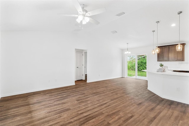 unfurnished living room with lofted ceiling, ceiling fan with notable chandelier, and dark hardwood / wood-style flooring