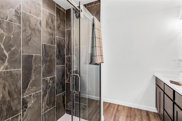 bathroom with vanity, hardwood / wood-style floors, and a shower with shower door