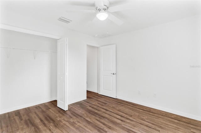 unfurnished bedroom with a closet, dark wood-type flooring, and ceiling fan