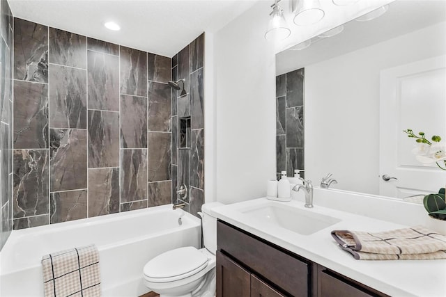 full bathroom with vanity, tiled shower / bath, and toilet