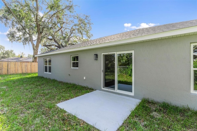 back of property featuring a patio and a lawn