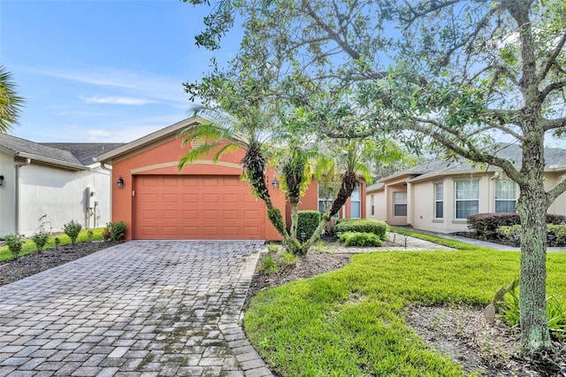 ranch-style home featuring a garage and a front lawn