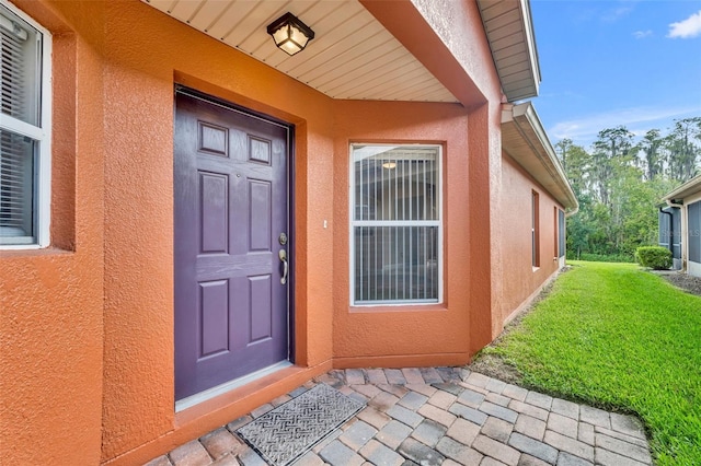540 Grand Canal Dr, Kissimmee, FL 34759 - view of exterior entry with a lawn and stucco siding